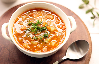 Veggies soup served in white bowl on a wooden plate.jpg