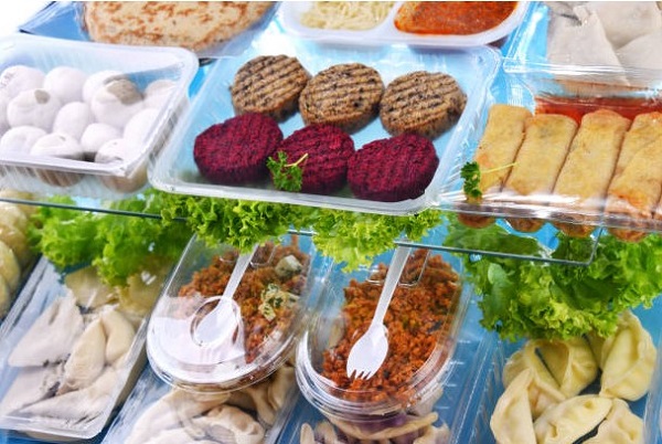 Clear plastic food containers in restaurant display cases.