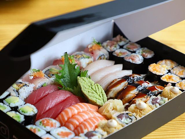 A cardboard sushi box with flip open top