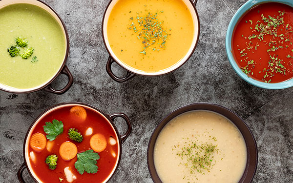different types of soups in bowls with handles